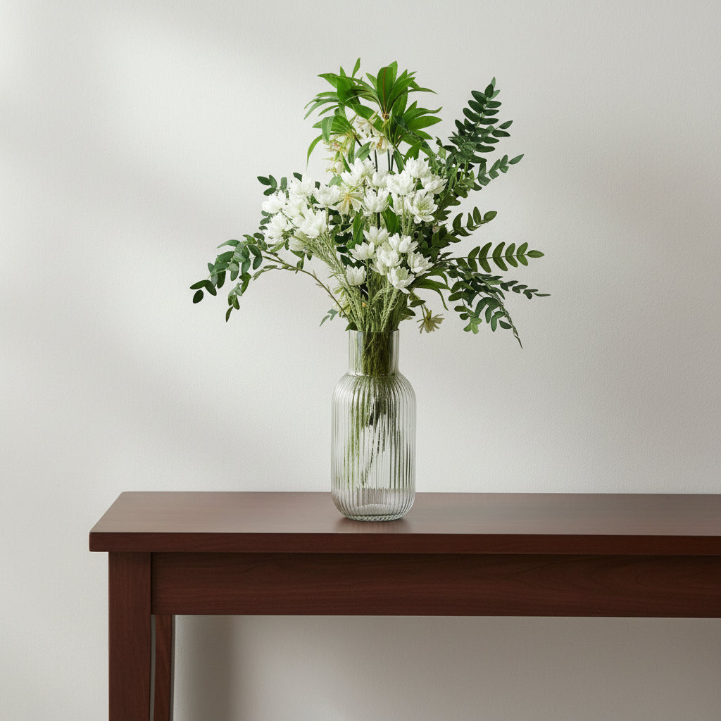 White artificial starflower arrangement in a ribbed glass vase on a walnut hall console