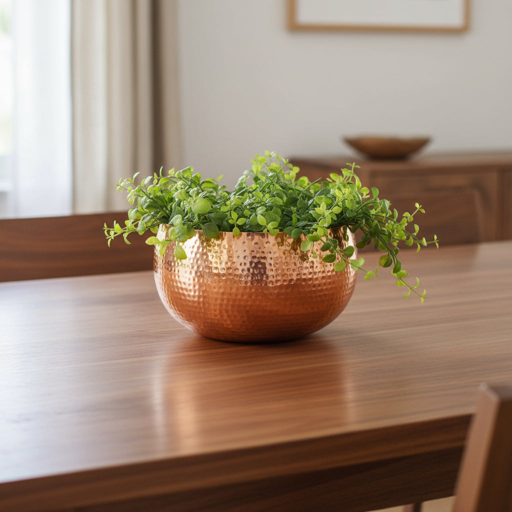 Hammered copper bowl planter as a centrepiece on a walnut dining table