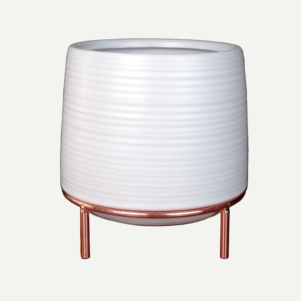 Ribbed white ceramic planter on slim copper legs