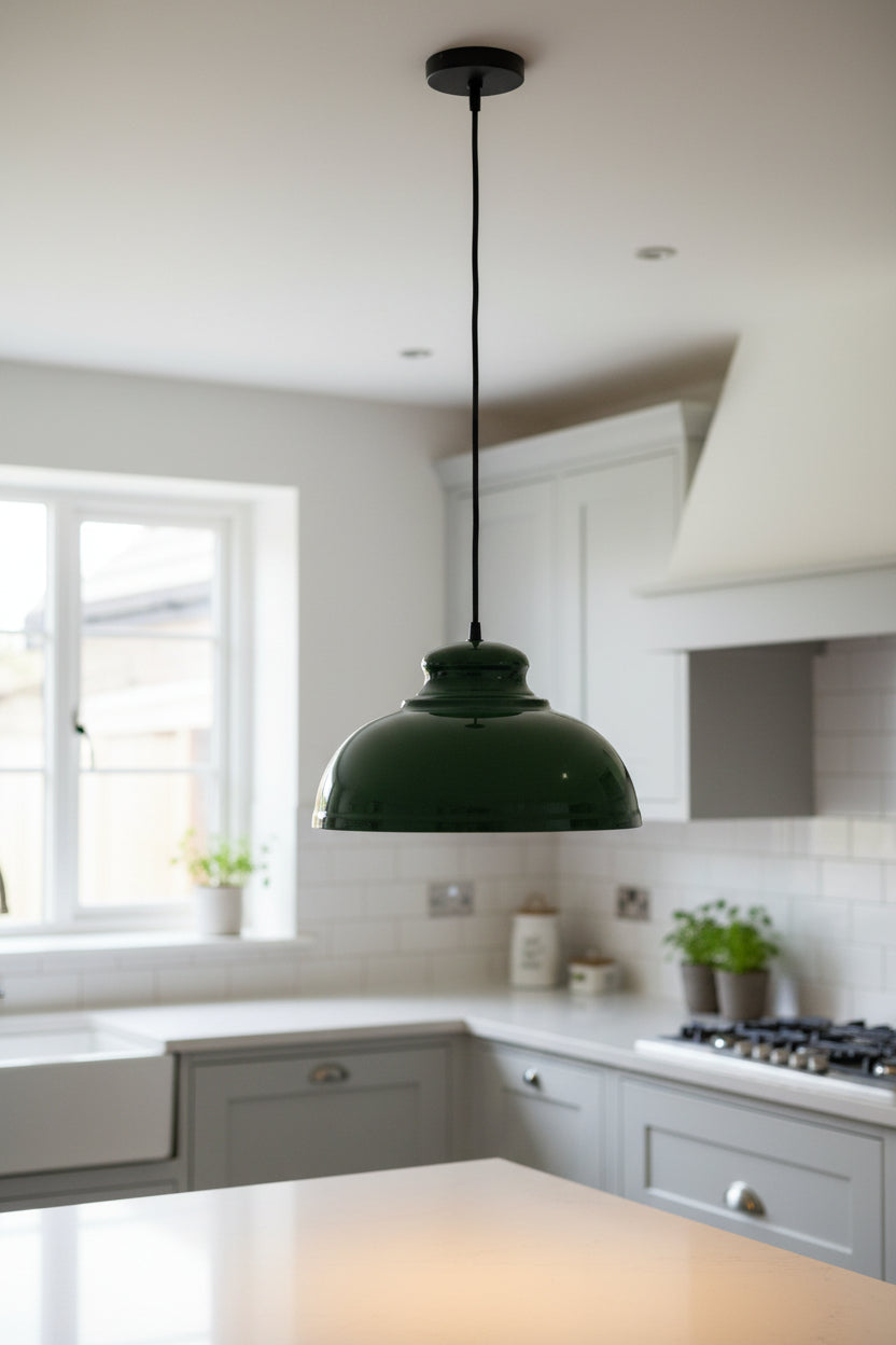 Dark green enamel dome shade hung on a black cord above a pale kitchen island
